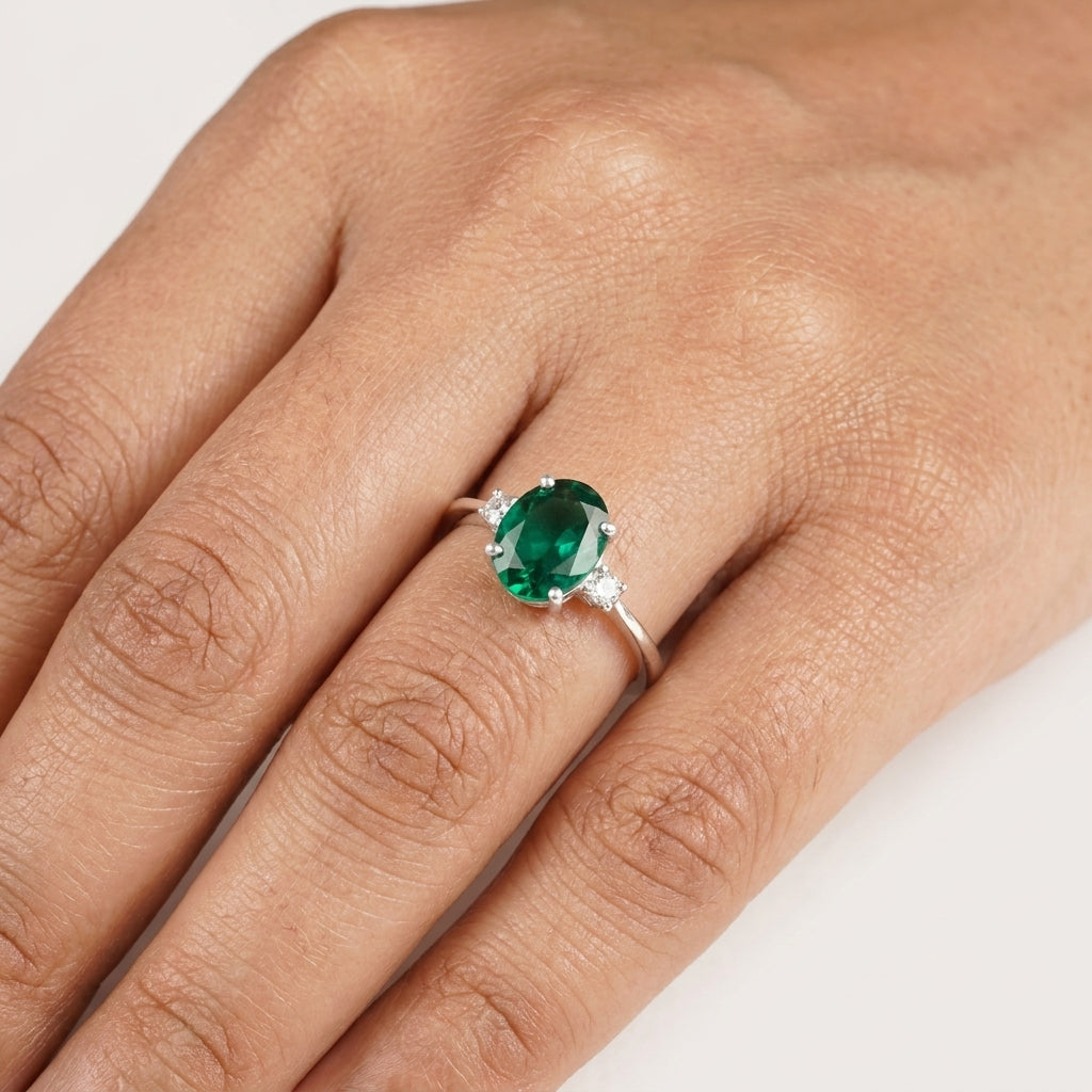 Oval Cut Emerald & Zirconia Three Stone Engagement Ring With Model Finger