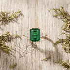 Baguette Cut Moissanite & Green Emerald Ring Stand On Table